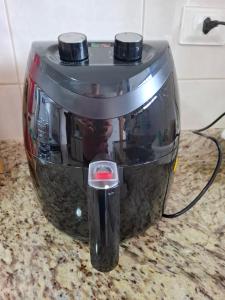 a coffee pot sitting on a counter with a cord at Apartamento Aconchegante 70m praia in Mongaguá