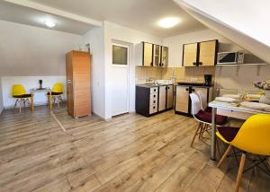 a kitchen and dining room with yellow chairs and a table at Mont Melis in Sînpetru +25 photos