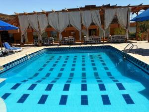 a large blue swimming pool with chairs and umbrellas at Nile Compound Garden in Al Aqālitah
