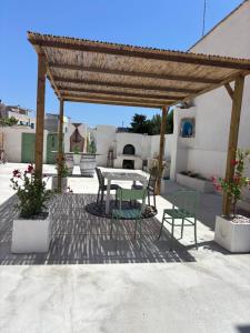 法维尼亚纳DIMORA DELLA CAVA Favignana的凉亭下有桌椅的露台