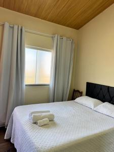 a bedroom with a bed with two towels on it at Suíte Casa de Luz-Lar na Serra-Quarto-01 - Duplo ou Triplo in Miguel Pereira