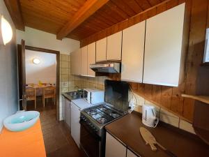 a kitchen with white cabinets and a stove top oven at Casa Gianeta in Pinzolo