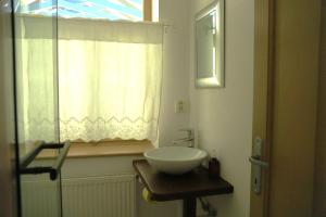 a bathroom with a white sink and a window at Bed&More Almáspuszta in Jestice +23 photos