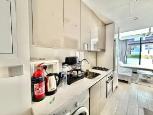 uma cozinha branca com pia e fogão em Luxury studio appartment em Sabkhah