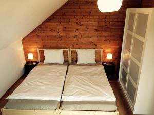 Bett in einem Zimmer mit einer Holzwand in der Unterkunft Winzerhaus mit Fernblick in Krems an der Donau