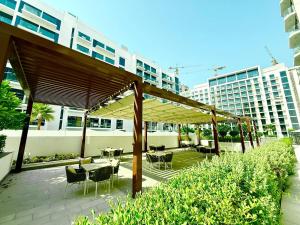 um pátio com mesas e cadeiras sob um dossel em Luxury studio appartment em Sabkhah