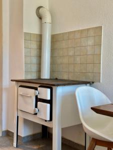 a stove in a kitchen with a blue chair at Belvedere Apartment - Riverside - Zentrum - Netflix - Liliensteinblick in Königstein an der Elbe