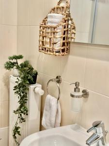 a bathroom with a sink and a basket on the wall at Belvedere Apartment - Riverside - Zentrum - Netflix - Liliensteinblick in Königstein an der Elbe +27 photos