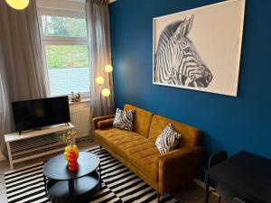 salon z kanapą i obrazem zebry na ścianie w obiekcie Kleines Zebra w mieście Gladbeck