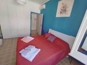 a bedroom with a red bed with towels on it at Alloggio panoramico sul mare di Vindicio in Formia