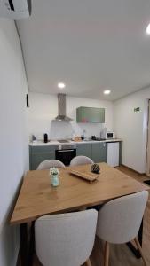 a kitchen with a wooden table and chairs at Casinhas do Campo by Gerês Valley in Campo do Gerês