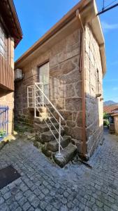 a stone house with a staircase on the side of it at Casinhas do Campo by Gerês Valley in Campo do Gerês
