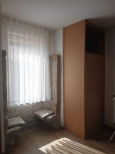 a living room with a window and a chair at Casinhas do Campo by Gerês Valley in Campo do Gerês