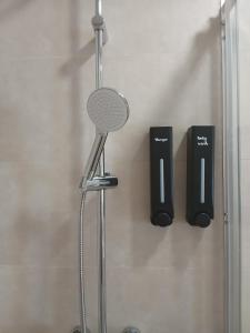 a shower with a shower head and two black speakers at Casinhas do Campo by Gerês Valley in Campo do Gerês +31 photos
