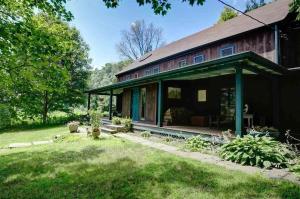 a barn house with a wrap around porch at Chestnut Hill Farm in Saugerties