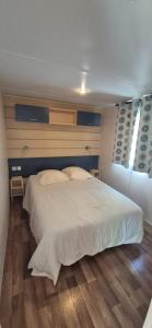 a bedroom with a large white bed and a wooden floor at L'échappée verte au bord de l'Eure in Ivry-la-Bataille +19 photos