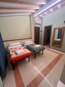 a room with two beds and a table and a mirror at La Madonnina-house in the Bolano vineyard in Bolano +10 photos