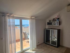 sala de estar con una puerta corredera de cristal que da a un balcón en Apartment More, en Novalja 12 fotos más