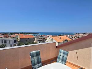 Una vista del océano desde un balcón con mesa y sillas. en Apartment More, en Novalja