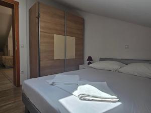 Una cama blanca con dos toallas encima. en Apartment More, en Novalja