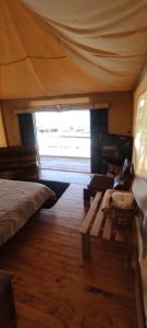 a bedroom with a bed and a couch and a window at Glamping Villa de Leyva in Estación El Salto