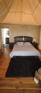 a bedroom with a large bed with a black rug at Glamping Villa de Leyva in Estación El Salto +8 photos