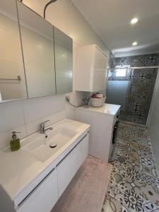 a white bathroom with a sink and a shower at YeldA in Fethiye