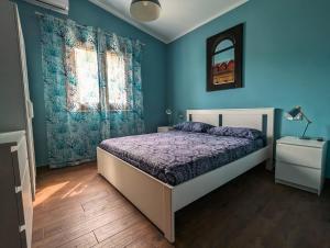 a bedroom with a bed and a blue wall at Villa Betta Cuntrariusa con piscina privata e jacuzzi a Scopello in Castellammare del Golfo +47 photos