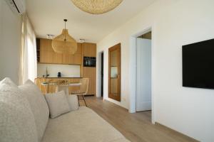 a living room with a couch and a tv and a kitchen at Balimood Stay in Palanga