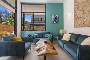 a living room with two blue couches and a table at Chic Bohemian Villa with a Private Swimming Pool and Stunning Outdoor Space in Coco