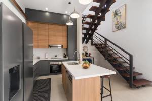 a kitchen with a sink and a refrigerator and a staircase at Chic Bohemian Villa with a Private Swimming Pool and Stunning Outdoor Space in Coco +28 photos