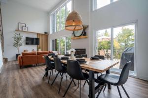 Saint ComeにあるLe Chalet des Hauts-Bois - Spa and Mountainのテーブルと椅子のあるダイニングルーム