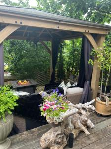 a gazebo with a couch and flowers on a table at PRIVATE HOUSE and private HOT TUB Seas The Day Pets BBQ Beaches Artists Studio Lower Gibsons The Bay in Gibsons