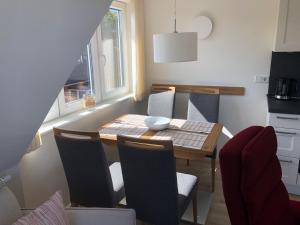 a dining room with a table and chairs and a kitchen at Haus Ostwind OSTWIND 'Levenslüst' in Langeoog