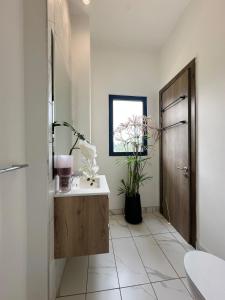 a bathroom with a sink and a wooden door at Happy Place Apartment in Gatunga