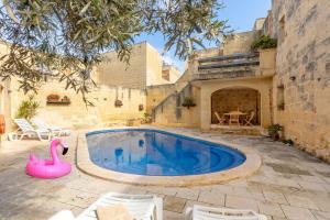 a swimming pool with a pink flamingo in a yard at Bebbuxija Pool Farmhouse Gozo - Happy Rentals in Xagħra +41 photos
