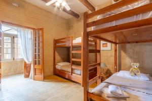 a bedroom with two bunk beds and a window at Bebbuxija Pool Farmhouse Gozo - Happy Rentals in Xagħra