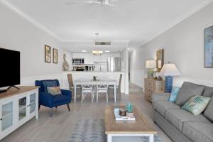 Una sala de estar con un sofá y un comedor. en 2004 Beach Villa - Captiva Two Bedroom Premier Beachfront Residence, en Captiva
