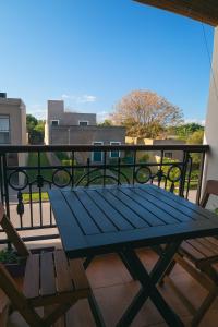 a blue picnic table on the balcony of a building at Loft La Mística in San Antonio de Areco
