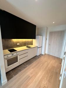 une cuisine avec des appareils blancs et un parquet dans l'établissement MILO Lux Apartments 3 - Belgrade Waterfront -Galerija, à Sajmište 8 autres photos