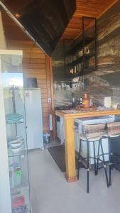 a kitchen with a counter and a refrigerator at Chalé dos Manacás 02 in Venda Nova do Imigrante