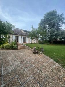 a house with a brick driveway in front of a yard at Maison village de Bigorre in Ossun