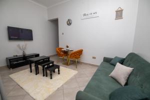 a living room with a green couch and a table at Kira Modern Elegance in Kampala
