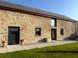 a brick building with two doors on the side at Reddaway Byre- brand new conversion in Okehampton