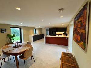 a living room with a table and a kitchen at Reddaway Byre- brand new conversion in Okehampton