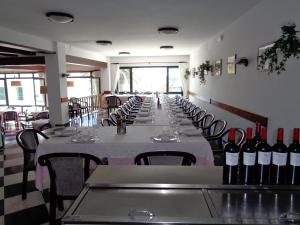 a row of tables in a restaurant with wine bottles at Hostal S'Algaret in Fornells