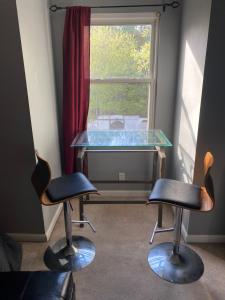 una mesa de cristal y 2 sillas frente a una ventana en Paul&Karen, en Nashville 2 fotos más