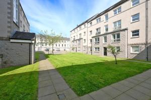 a grassy yard in front of a building at Central Two Bedroom Apartment Near Union Square -Free Parking in Aberdeen