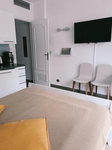 1 dormitorio con 2 sillas y TV en la pared en Your favorite apartments, en Menton 10 fotos más
