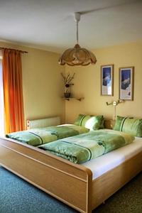 een slaapkamer met een groot bed met groene lakens bij Haus Silvia in Werfenweng